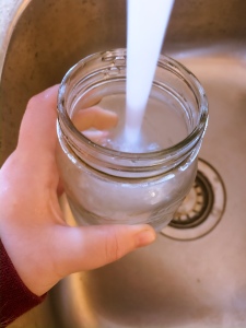 sink tap flow of water filling a drinking glass